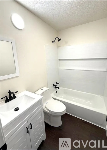 A white bathroom with a toilet, sink, and bathtub.
