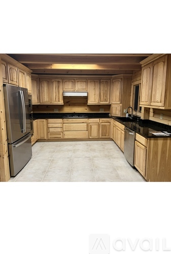 A kitchen with wooden cabinets and a black countertop.