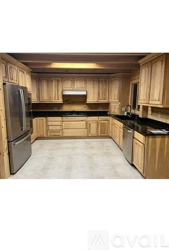A kitchen with wooden cabinets and a black countertop.