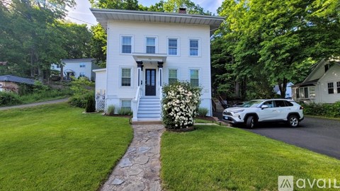 A white house with a stone pathway leading to the front door.