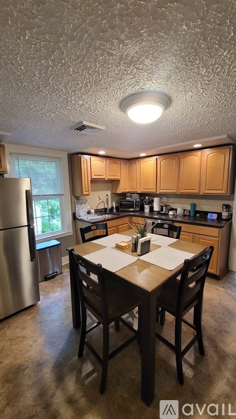 A kitchen with a table and chairs in the middle of the room.
