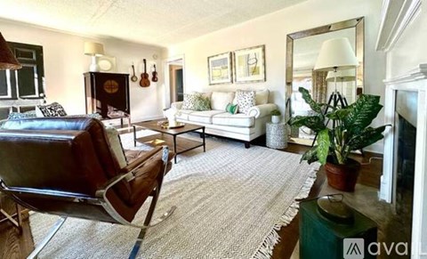 A living room with a brown leather chair and a white couch.