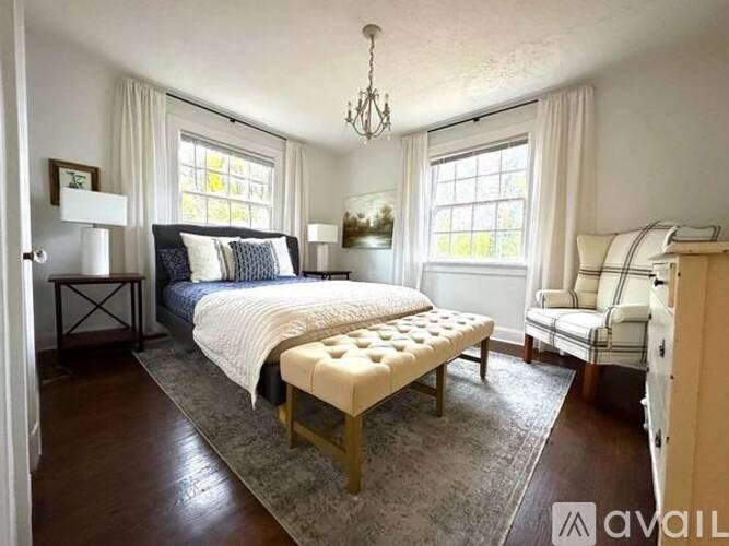 A bedroom with a large bed and a bench in front of it.