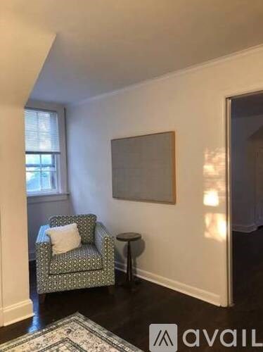 A living room with a green patterned chair and a small table.