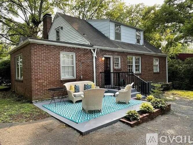 A house with a brick exterior and a patio with chairs.
