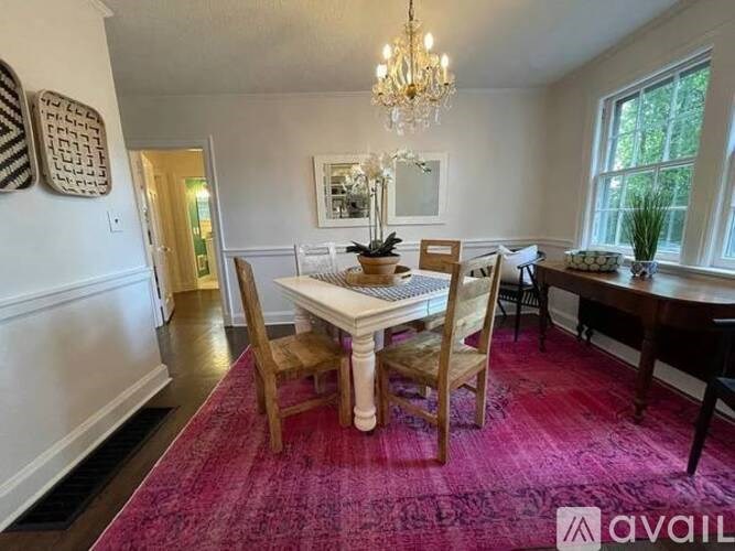 A dining room with a white table and chairs.