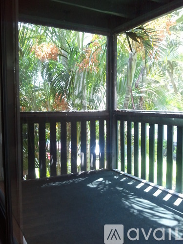 A balcony with a view of a lush green forest.