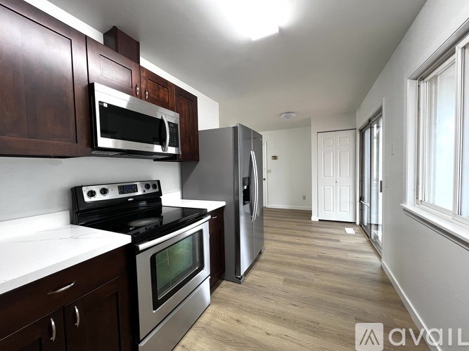 A kitchen with dark wood cabinets and stainless steel appliances.