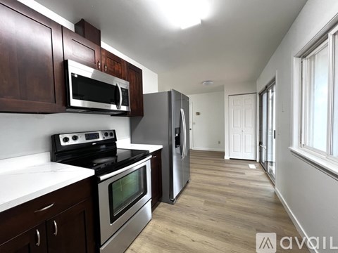 A kitchen with dark wood cabinets and stainless steel appliances.
