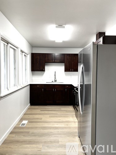 A kitchen with a refrigerator on the right side.