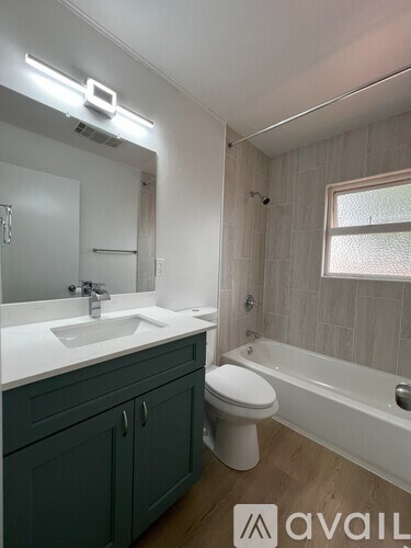 A bathroom with a white sink, toilet, and bathtub.
