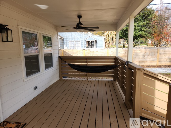 A wooden deck with a hammock and a ceiling fan.