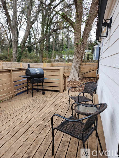 A patio with a grill and chairs.