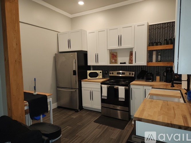 A kitchen with a black stove top oven and a black fridge.