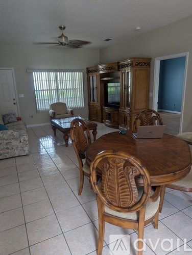 A living room with a wooden table and chairs.