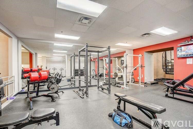 A gym with a variety of equipment including a bench, weights, and a treadmill.