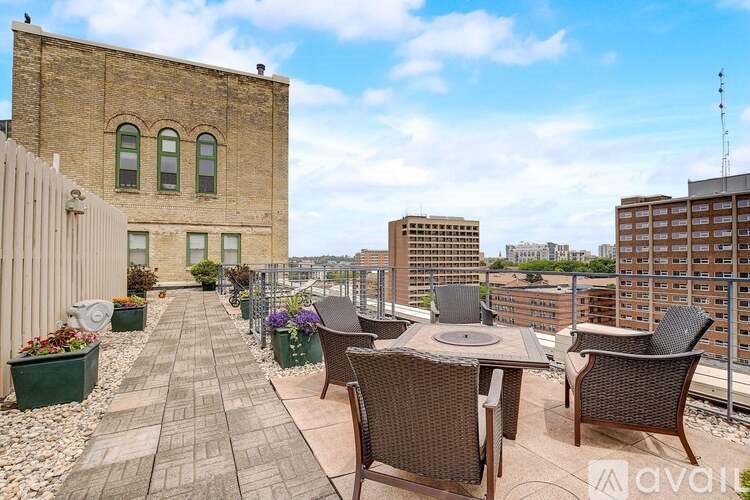 A patio with a table and chairs overlooks a cityscape.