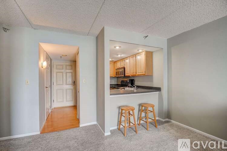 A kitchen area with a bar stool in front of it.