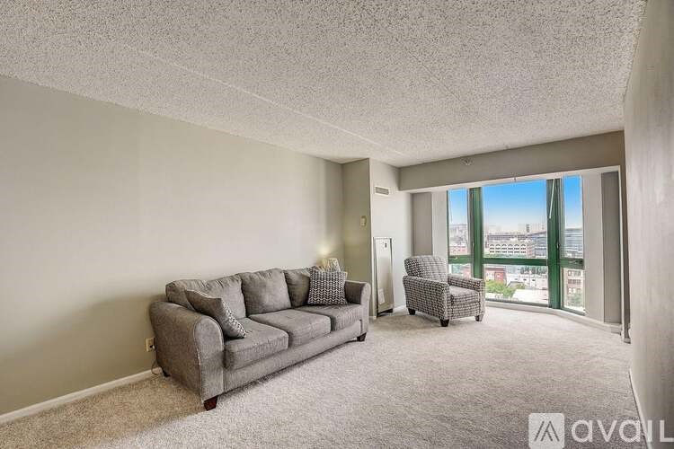 A living room with a grey couch and a chair.