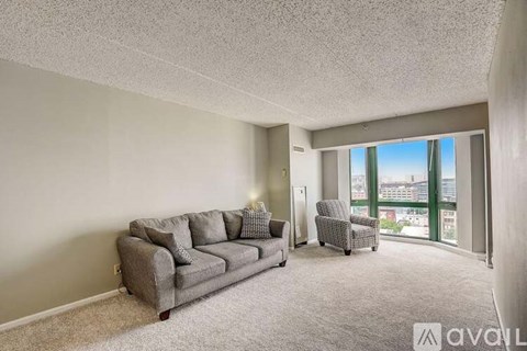 A living room with a grey couch and a chair.