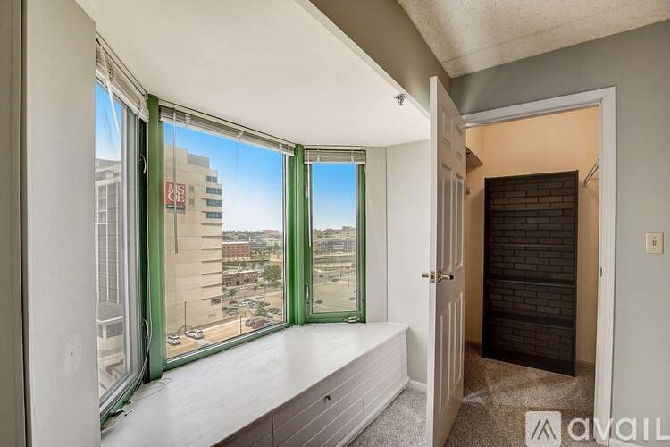 A room with a view of a parking lot through the window.