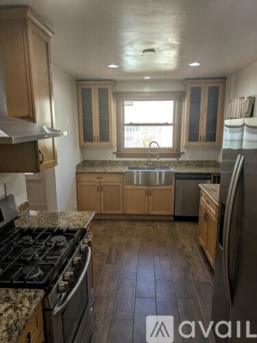 A kitchen with wooden cabinets and a granite countertop.