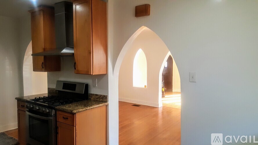 A kitchen with wooden cabinets and a black stove top oven.