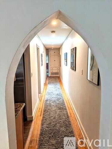 A hallway with a carpeted floor and white walls.