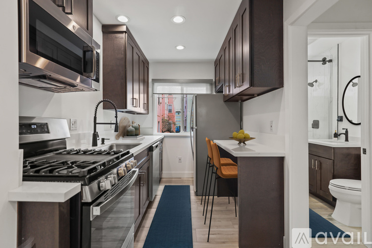 A modern kitchen with dark brown cabinets and a stainless steel stove.