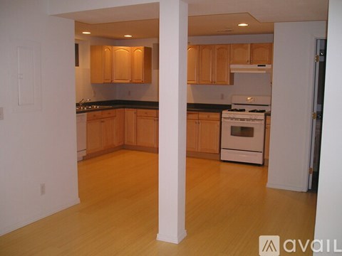 A kitchen with wooden cabinets and a white stove.