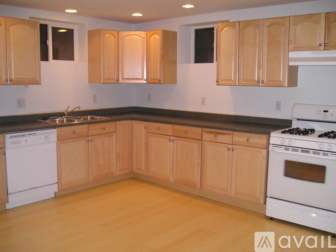 A kitchen with wooden cabinets and a white dishwasher.