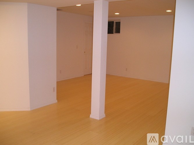A room with wooden flooring and white walls.