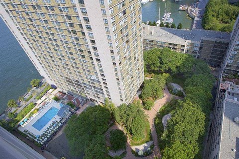 an aerial view of a building with a pool and trees
