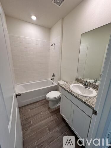 A bathroom with a toilet, sink, and bathtub.