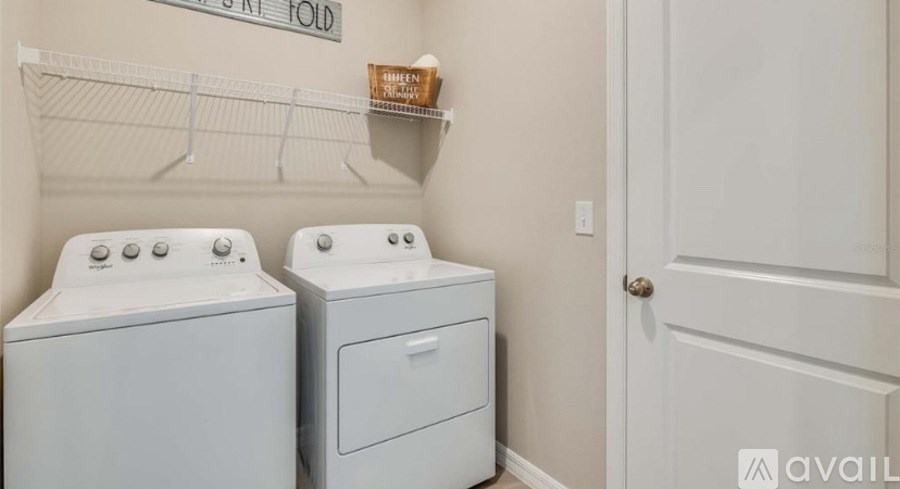 Two white front loading washing machines in a laundry room.