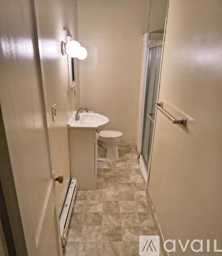 A bathroom with a toilet, sink, and mirror.