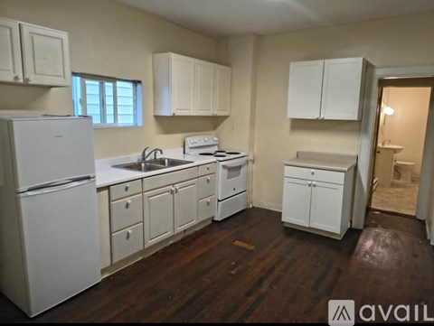 A kitchen with white appliances and cabinets.