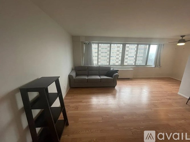 A living room with a grey sofa and wooden flooring.