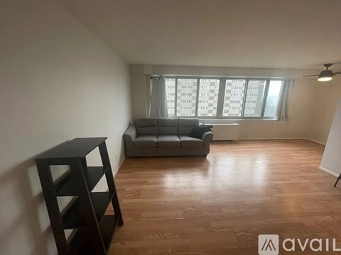 A living room with a grey sofa and wooden flooring.