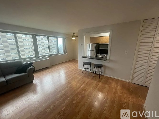 A living room with a couch, a bar stool, and a television.