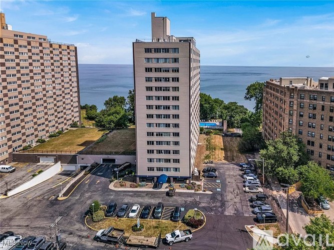 A parking lot with cars and a building in the background.