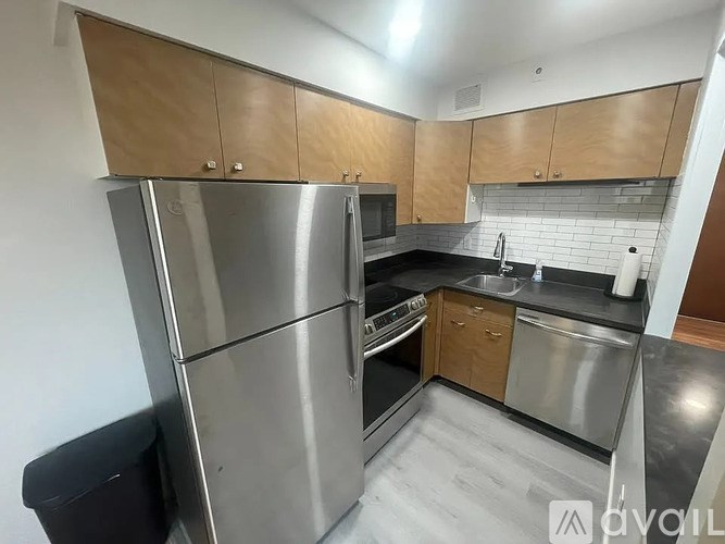 A kitchen with a stainless steel refrigerator, microwave, and oven.