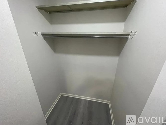 A white wall with a metal shelf and a grey floor.