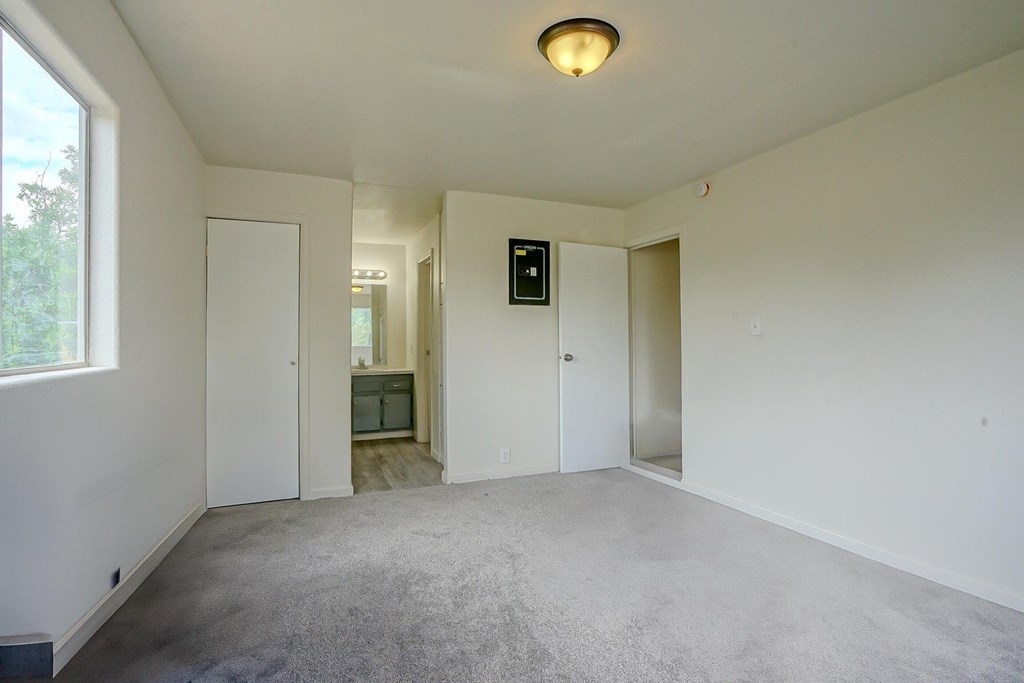 A room with a carpeted floor and a white ceiling with a light fixture.