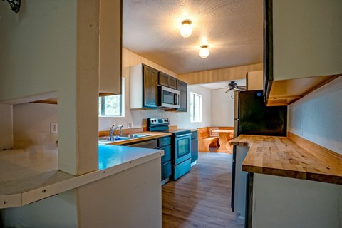 A kitchen with a blue refrigerator and wooden countertops.