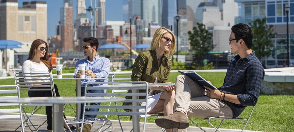 a group of people sitting at tables in a park
