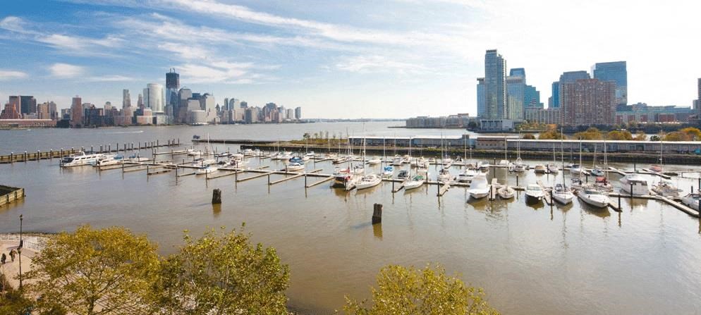 a harbor full of boats with a city in the background