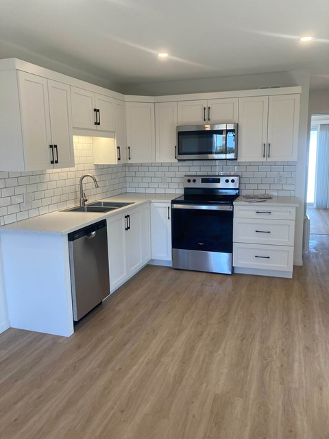 A kitchen with white cabinets and a black stove top oven.
