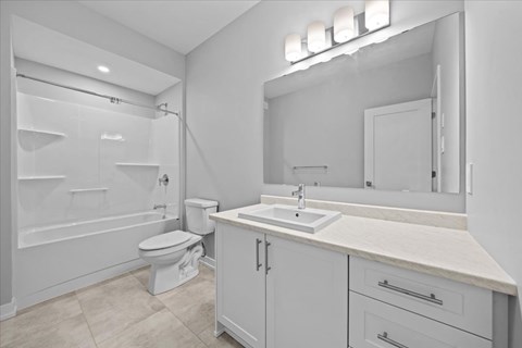 A white bathroom with a toilet, sink, and bathtub.