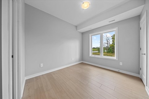 A room with a window and wooden flooring.